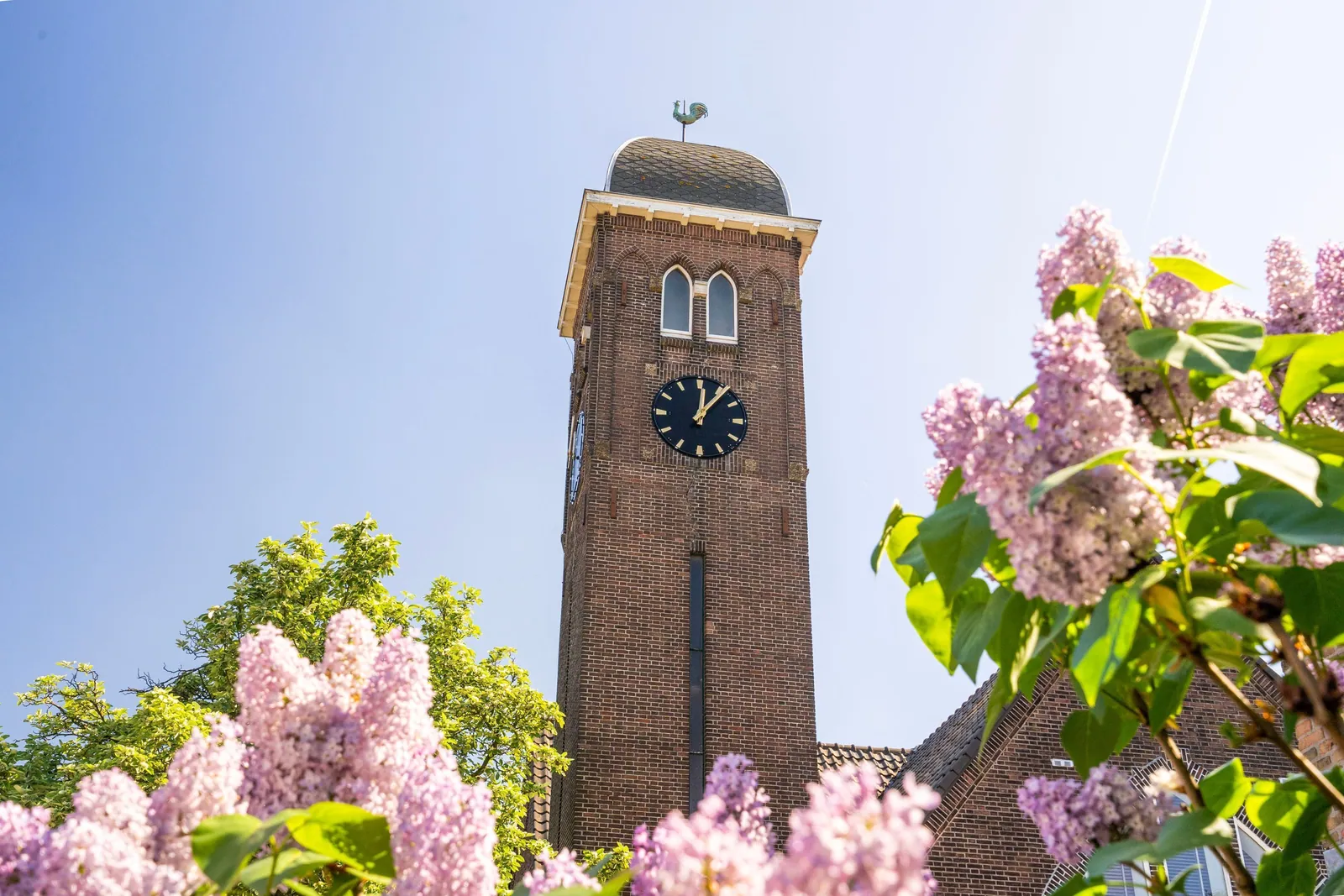 Elimkerk, Heijplaat Rotterdam – de toren met de klok, tussen bloeiende seringen
